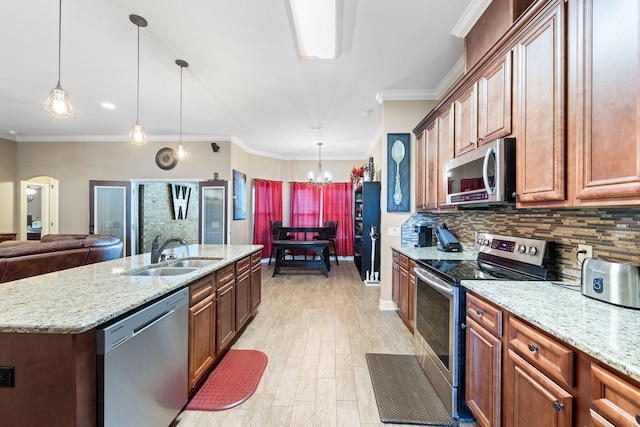 kitchen featuring stainless steel appliances, decorative backsplash, a sink, and crown molding