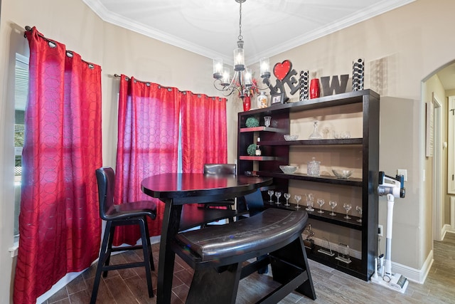 dining area featuring arched walkways, a chandelier, crown molding, and wood finish floors