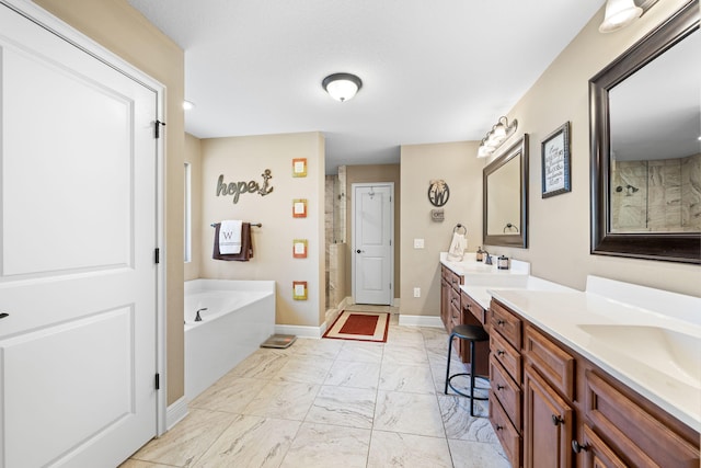 bathroom with marble finish floor, a garden tub, a stall shower, vanity, and baseboards