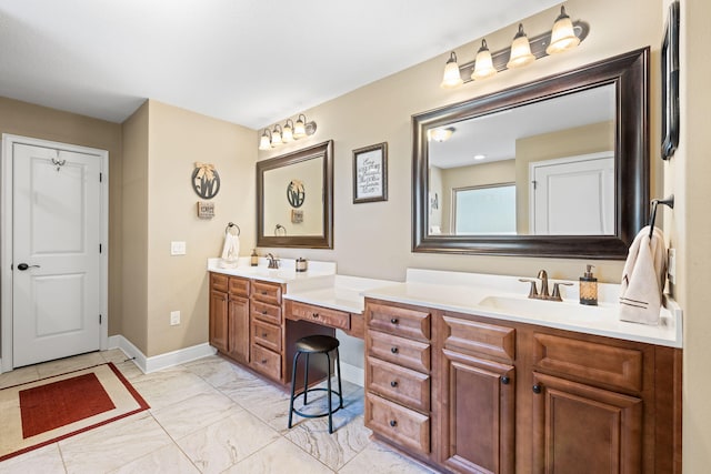 bathroom featuring double vanity, marble finish floor, baseboards, and a sink