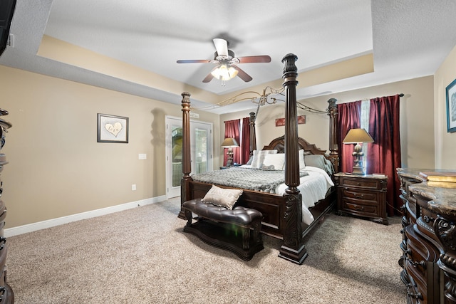 carpeted bedroom with access to outside, a raised ceiling, ceiling fan, and baseboards