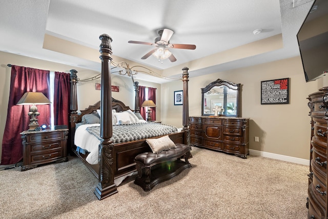 bedroom featuring carpet floors, ceiling fan, baseboards, and a raised ceiling