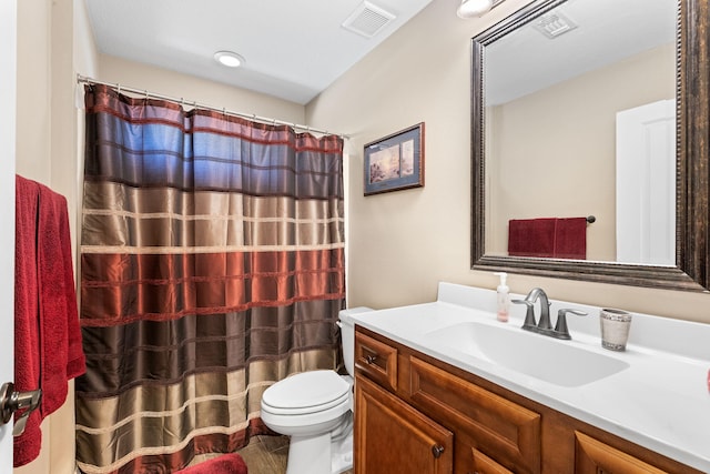 bathroom with toilet, visible vents, a shower with shower curtain, and vanity