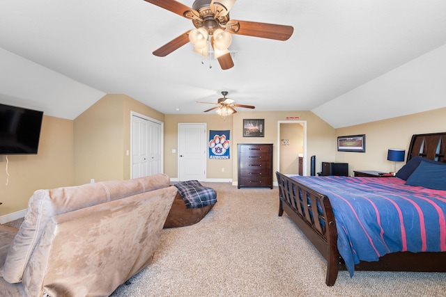 bedroom featuring carpet, lofted ceiling, ensuite bathroom, a ceiling fan, and baseboards