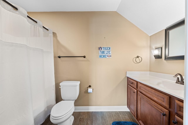 bathroom with baseboards, lofted ceiling, toilet, wood finished floors, and vanity