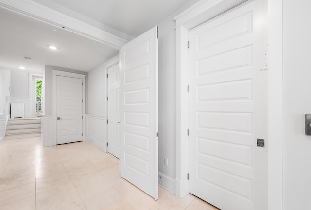 hall featuring light tile patterned floors, a wainscoted wall, and recessed lighting