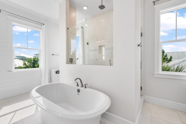 bathroom with a freestanding bath, a shower stall, and baseboards