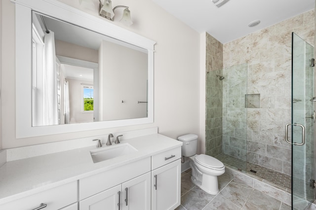 bathroom featuring vanity, a shower stall, toilet, and tile patterned floors