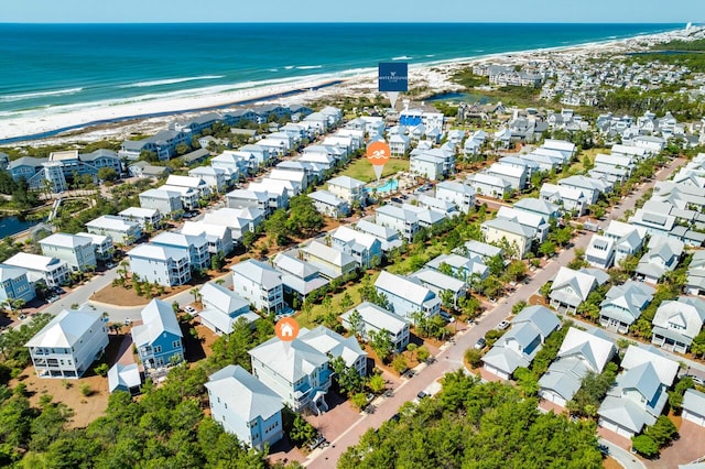 drone / aerial view featuring a water view, a residential view, and a view of the beach