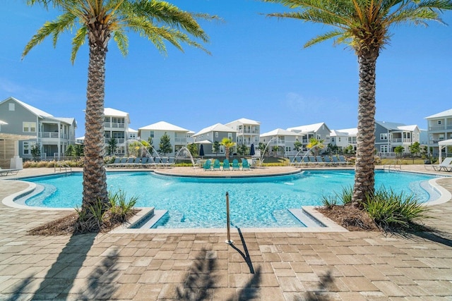 community pool with a residential view, fence, and a patio