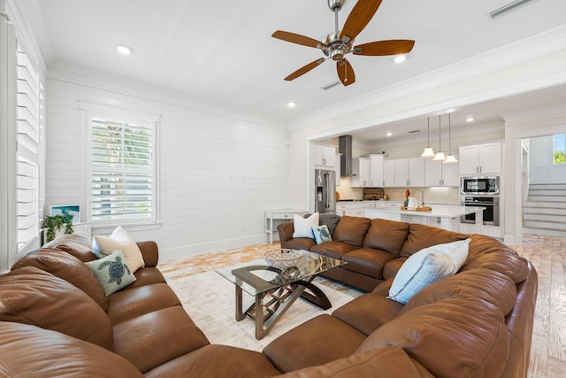 living area featuring visible vents, crown molding, and light wood finished floors