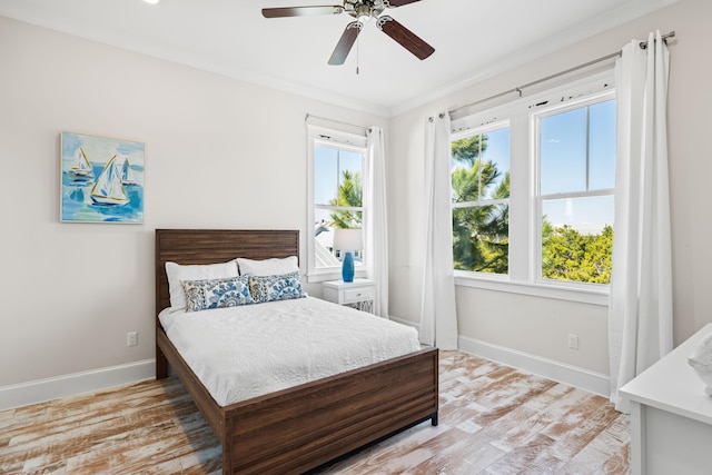 bedroom with ceiling fan, light wood-style flooring, and baseboards