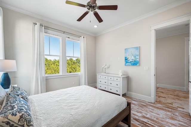 bedroom featuring a ceiling fan, crown molding, baseboards, and wood finished floors