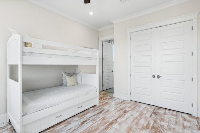 unfurnished bedroom featuring baseboards, ornamental molding, wood finished floors, a closet, and recessed lighting