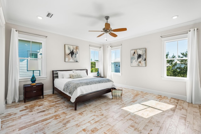 bedroom with ornamental molding, visible vents, and multiple windows