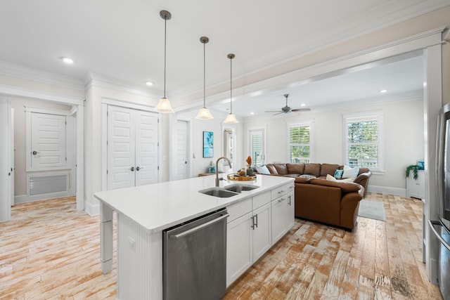 kitchen with a sink, open floor plan, light countertops, ornamental molding, and stainless steel dishwasher