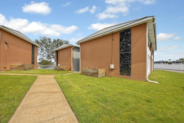 view of side of home with a lawn and stucco siding