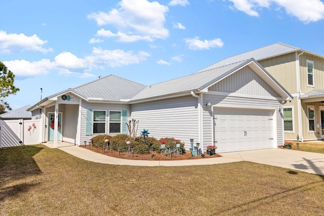 ranch-style house with an attached garage, metal roof, fence, driveway, and a front lawn