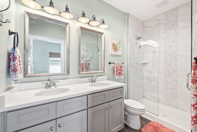 full bath with double vanity, a stall shower, and a sink