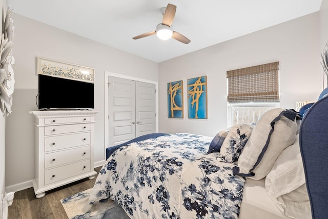 bedroom featuring a closet, dark wood-style flooring, baseboards, and a ceiling fan