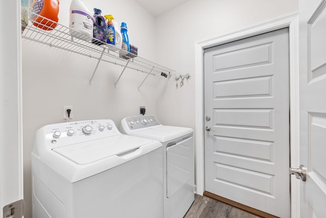 washroom with laundry area, separate washer and dryer, and wood finished floors