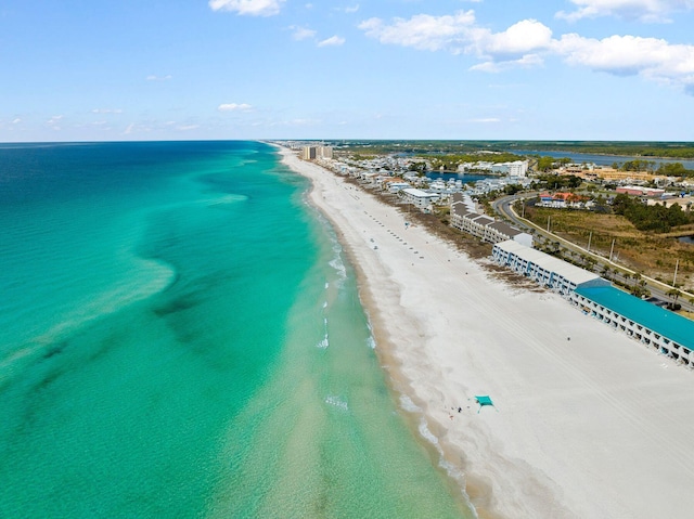 birds eye view of property with a water view and a beach view