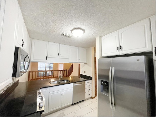 kitchen featuring stainless steel appliances, a sink, visible vents, marble finish floor, and dark countertops