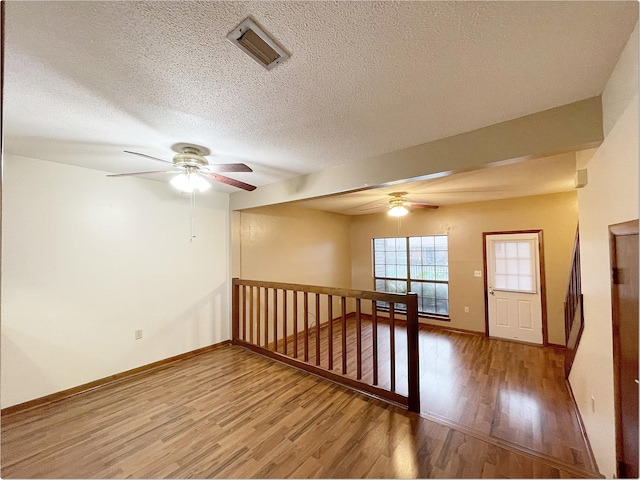 spare room featuring visible vents, baseboards, and wood finished floors