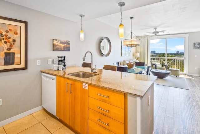 kitchen with pendant lighting, a sink, a peninsula, light stone countertops, and dishwasher