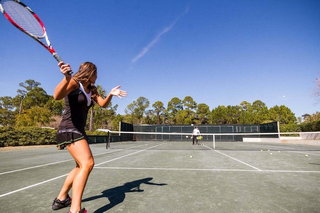 view of tennis court featuring fence