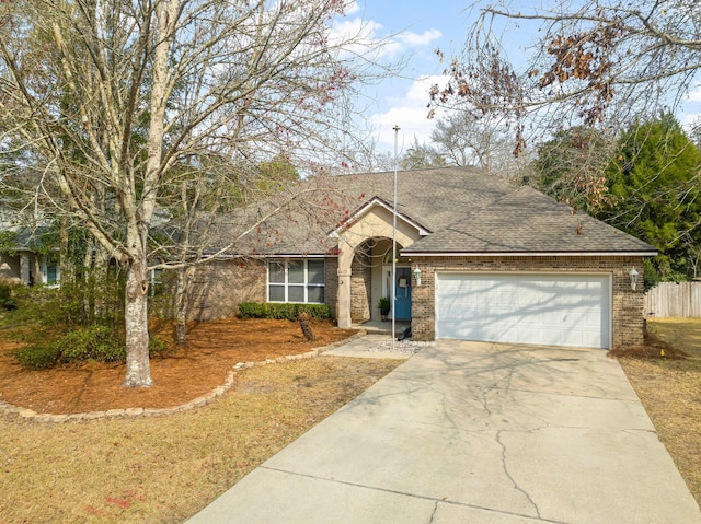 ranch-style house featuring an attached garage, brick siding, fence, driveway, and roof with shingles