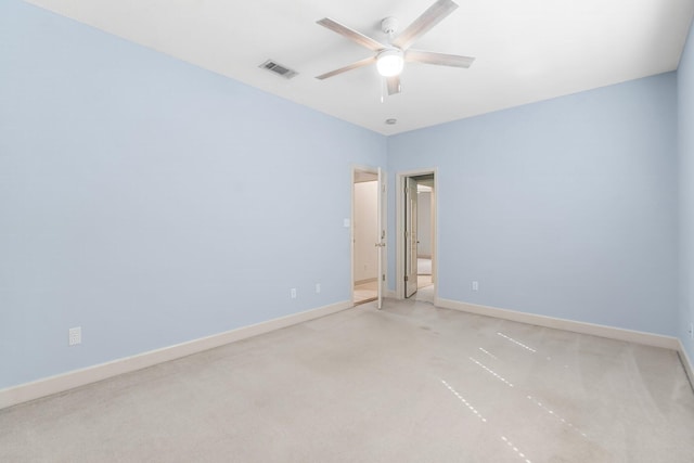 empty room featuring visible vents, ceiling fan, and baseboards