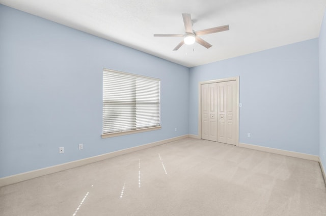 unfurnished bedroom featuring a closet, carpet flooring, a ceiling fan, and baseboards