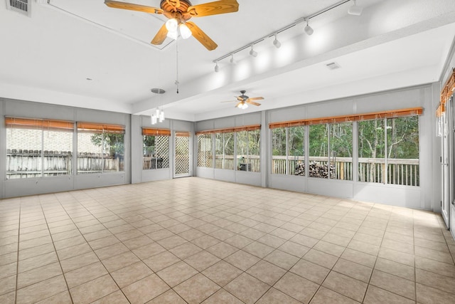 unfurnished sunroom with plenty of natural light, visible vents, and a ceiling fan