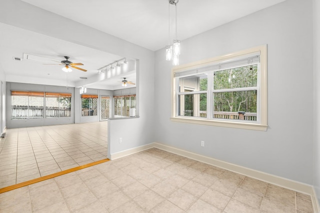 empty room with ceiling fan, visible vents, baseboards, and track lighting