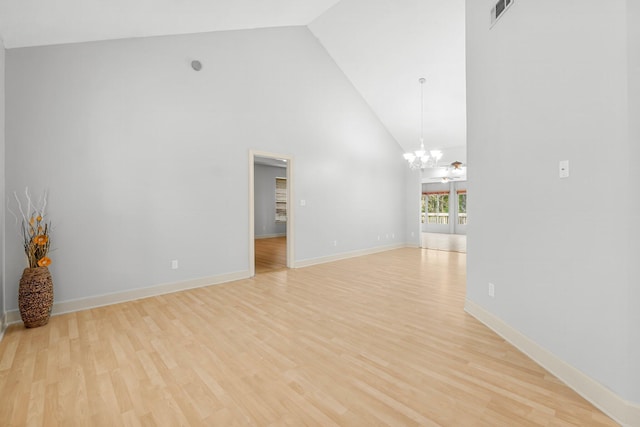 empty room featuring light wood-style floors, baseboards, visible vents, and a notable chandelier