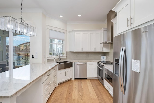 kitchen with stainless steel appliances, a peninsula, a sink, wall chimney range hood, and tasteful backsplash