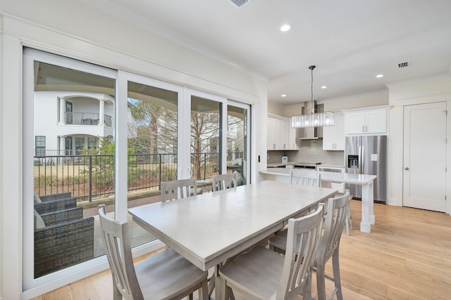 dining room with light wood finished floors, visible vents, ornamental molding, and recessed lighting