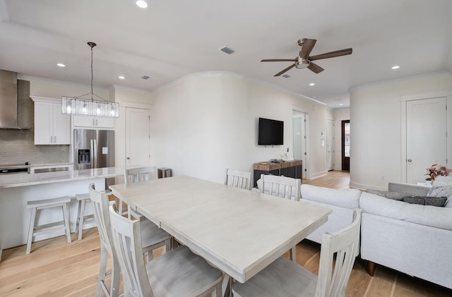 dining room with recessed lighting, visible vents, ornamental molding, light wood-type flooring, and ceiling fan with notable chandelier