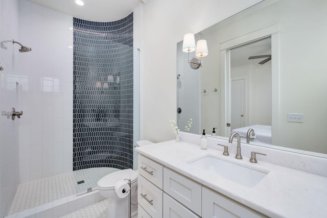 bathroom featuring tiled shower, vanity, and toilet