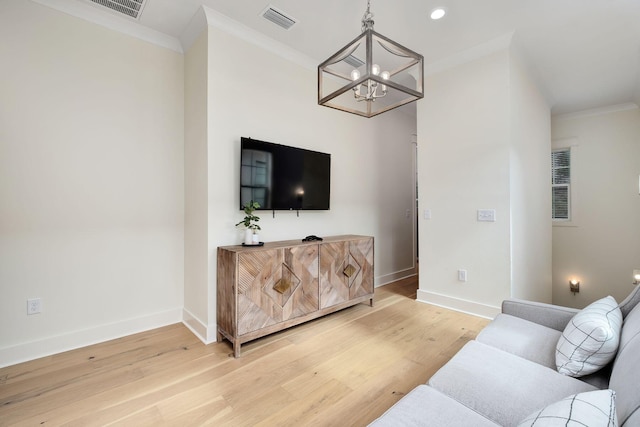 living room with a chandelier, visible vents, baseboards, light wood-type flooring, and crown molding