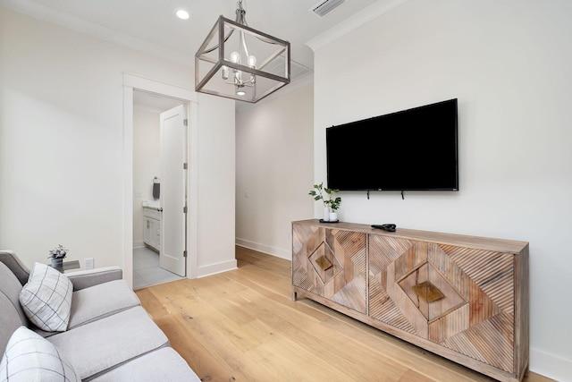 living area featuring baseboards, light wood-style flooring, crown molding, a chandelier, and recessed lighting