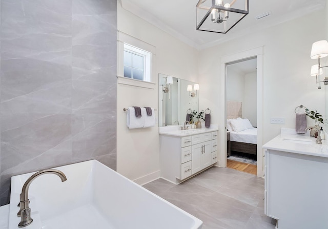 ensuite bathroom featuring a soaking tub, crown molding, vanity, and ensuite bath