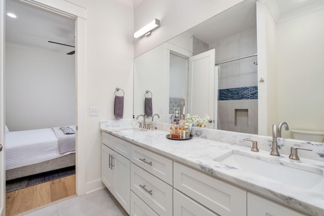 ensuite bathroom featuring double vanity, ornamental molding, a sink, and ensuite bathroom