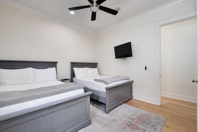 bedroom with visible vents, ornamental molding, a ceiling fan, light wood-type flooring, and baseboards