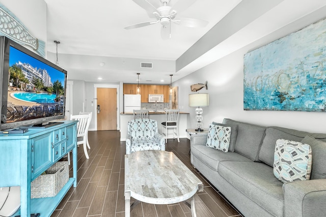 living area featuring a ceiling fan, wood finish floors, visible vents, and recessed lighting