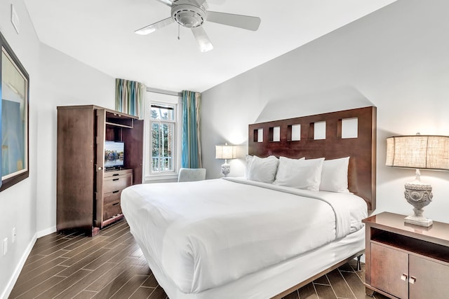 bedroom featuring baseboards, dark wood finished floors, and a ceiling fan