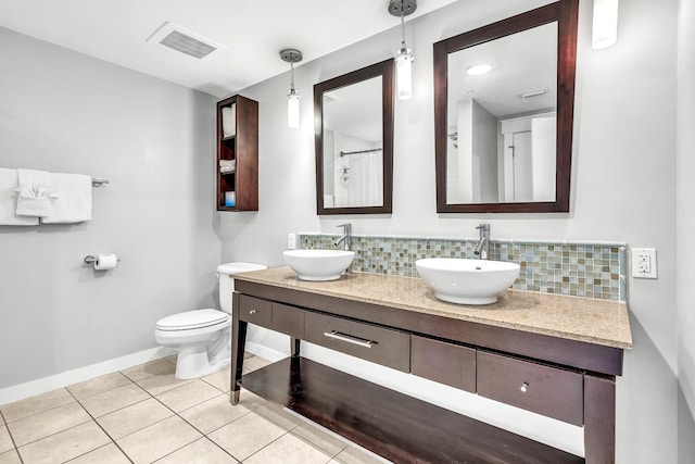 bathroom with tile patterned flooring, tasteful backsplash, visible vents, and a sink