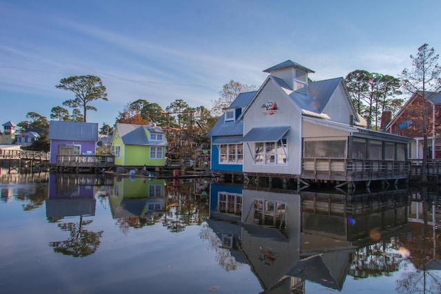 rear view of property featuring a water view and metal roof