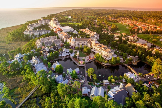 aerial view at dusk featuring a water view